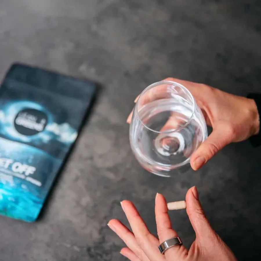 A single Drift Off capsule held beside a glass of water