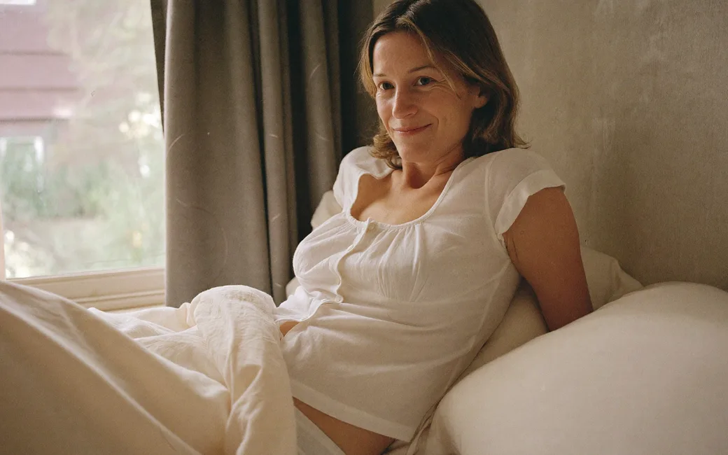 A woman waking naturally in soft morning light, rested